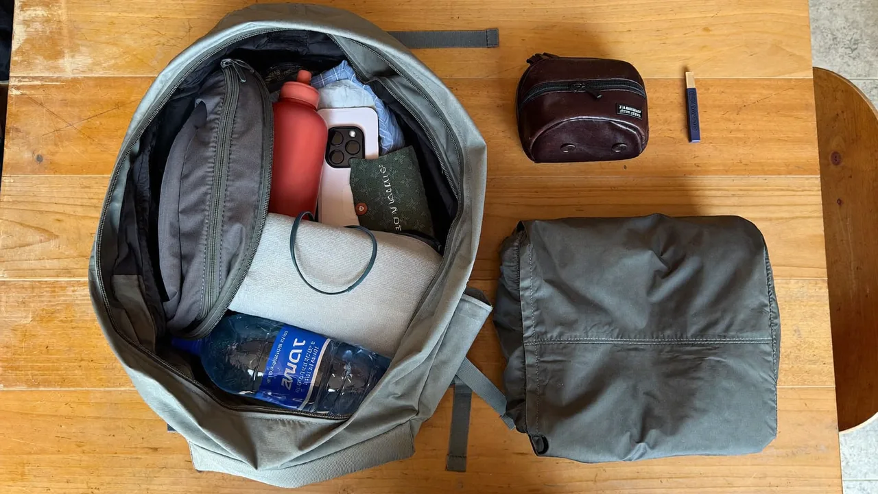 日帰り旅行用リュックを開けて水筒や折りたたみ傘などの中身を並べた様子